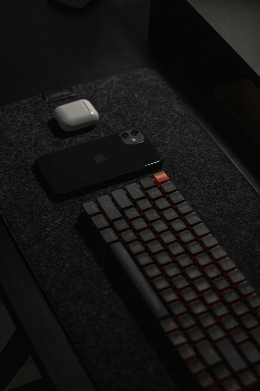 a red keyboard and wireless mouse sit on top of the desk