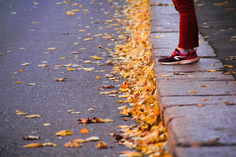 a woman in red pants is walking on the street