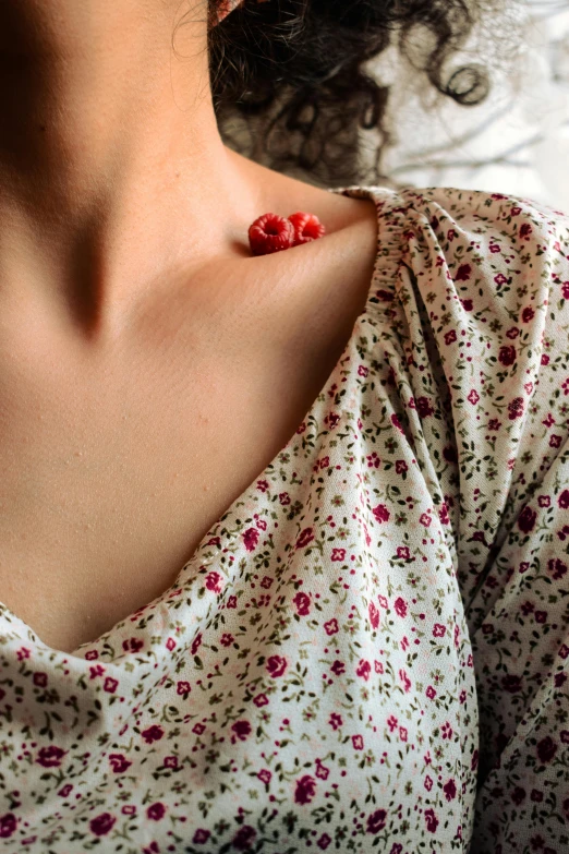 the woman has a red brooch on her collar