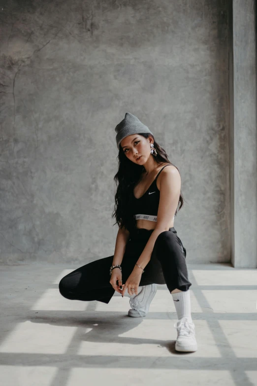 a woman sits on the ground wearing black pants