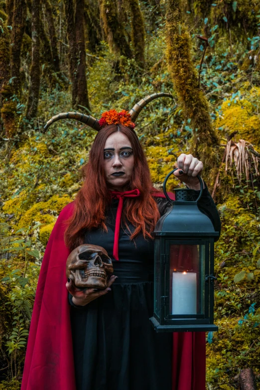 a person with long hair holding a lantern and wearing red in their hands