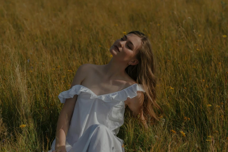 woman lying in the grass in a white dress