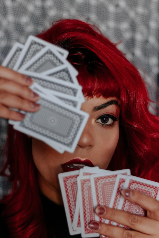 a woman holding four deck cards with her right hand