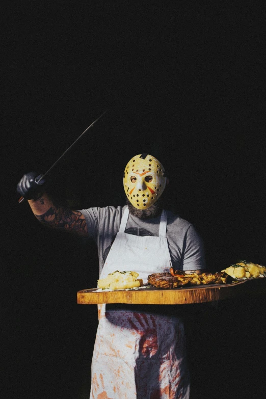 a man wearing a mask holding a tray of food