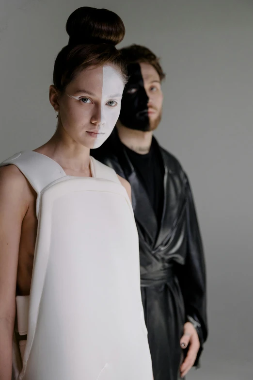 a man with a costume as a mask standing next to a model with an un - facial mask on her face