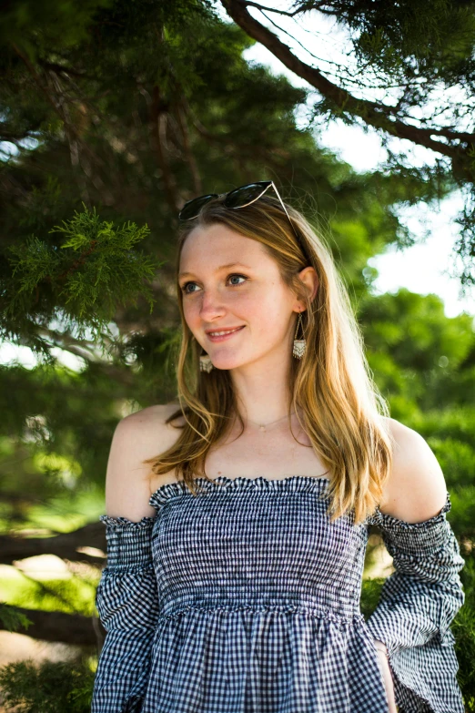 a woman wearing plaid shirt and jeans with her hands on hips