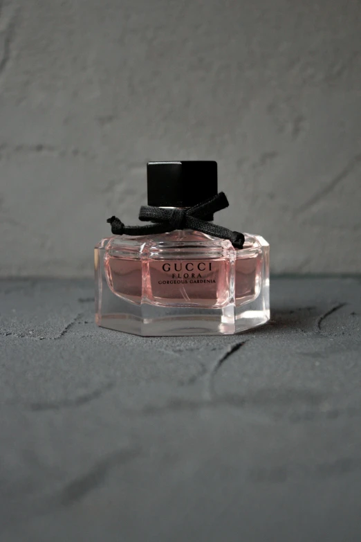 a bottle of gucci by gucci in a glass container