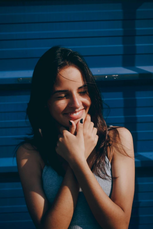 a woman is posing with her hand on her face