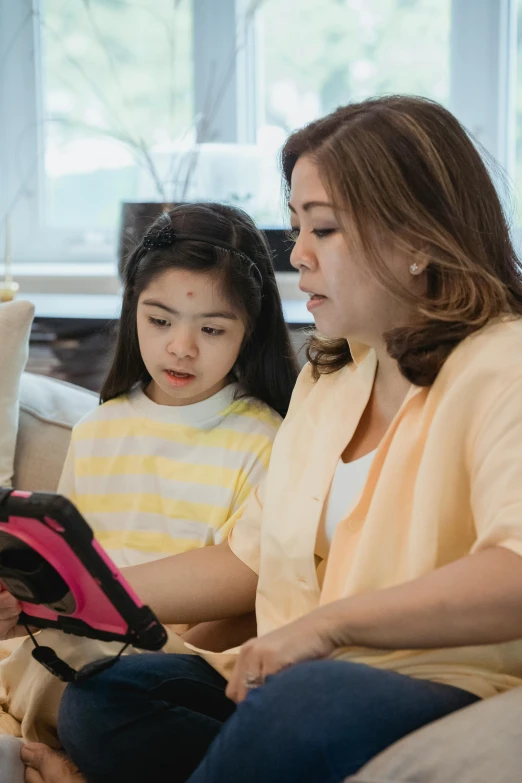 a mother and daughter looking at soing on a tablet