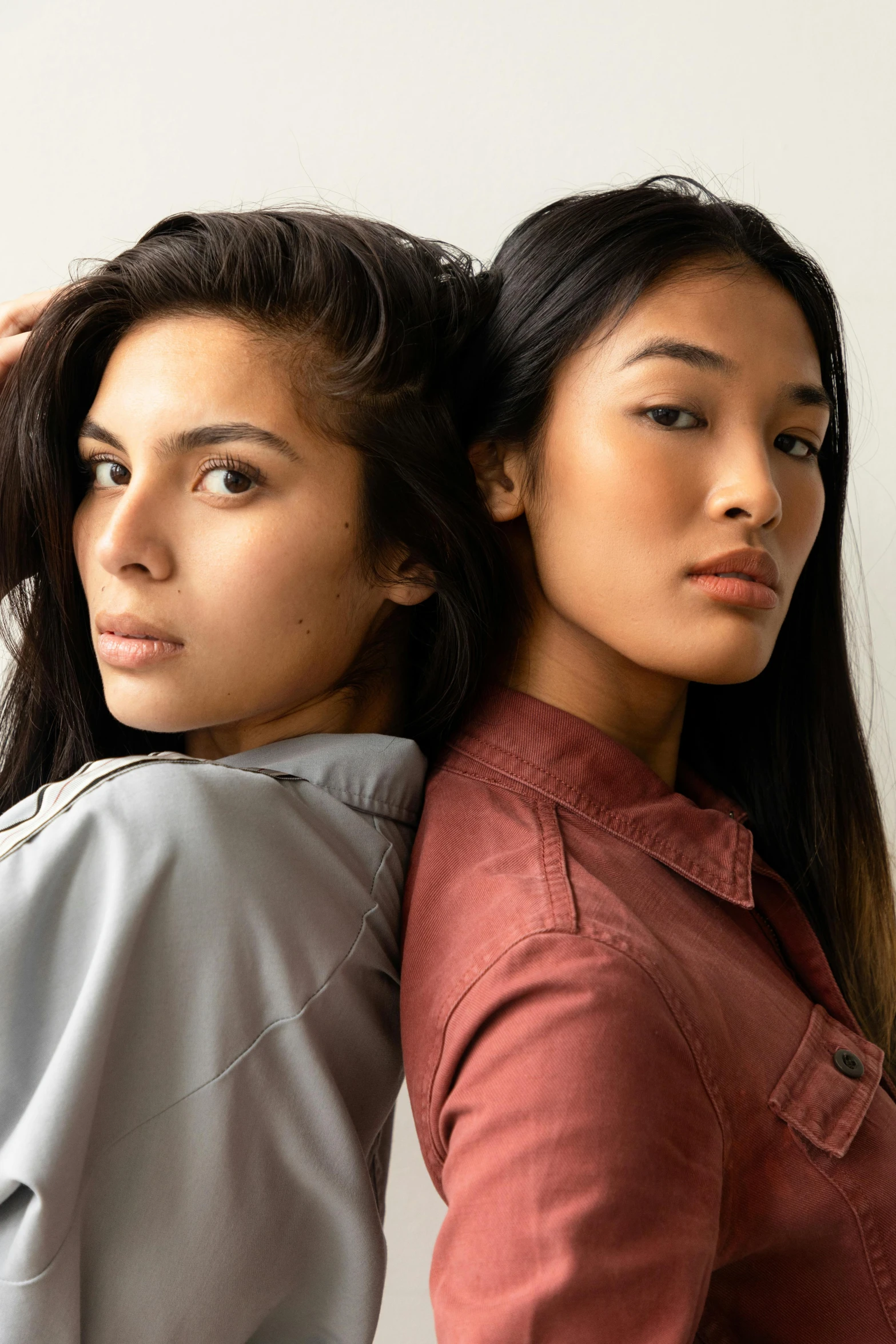 two young women with ponytails stand next to each other