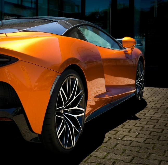 an orange sports car parked on the side of a street