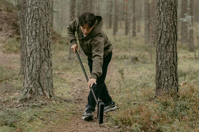 a woman with an umbrella walking in the woods