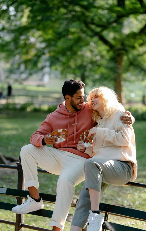 two men and a woman sitting on a bench