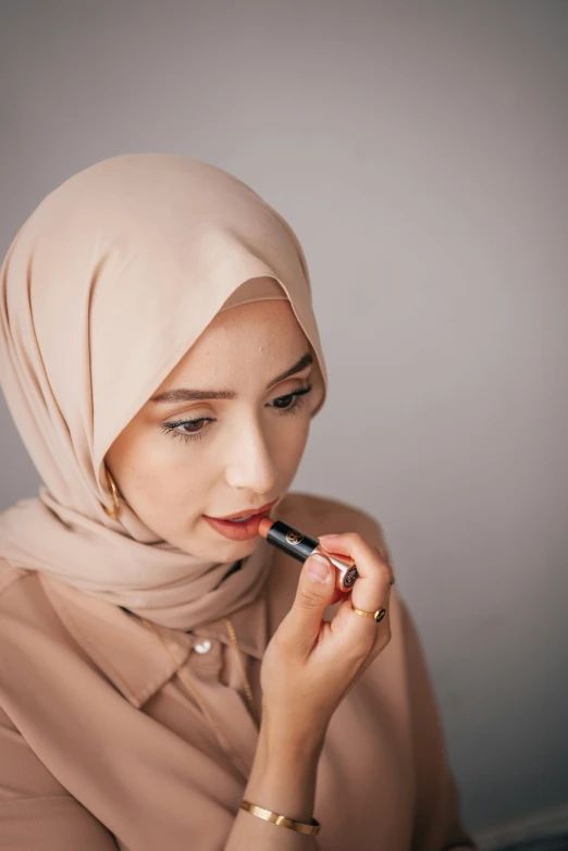 a woman wearing a hijab with her hands on the lip