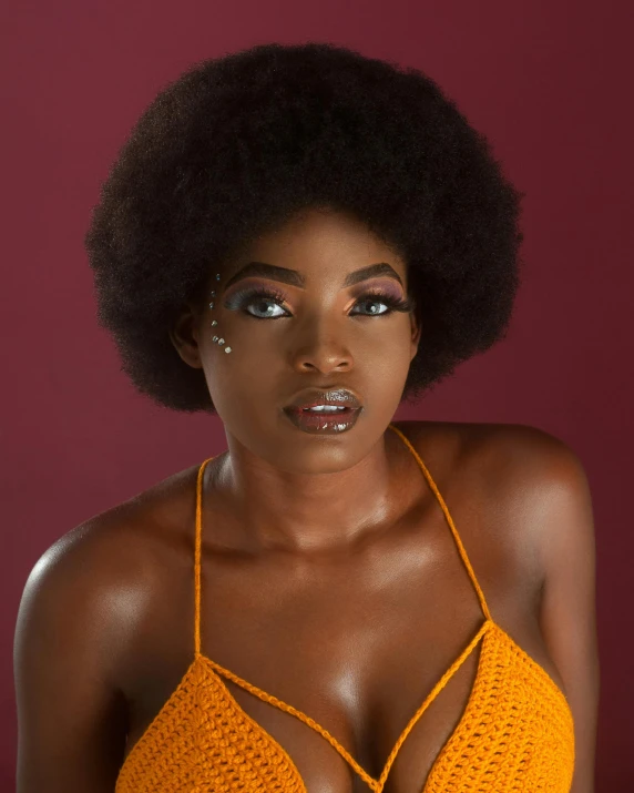 a woman with an afro in a yellow halter top