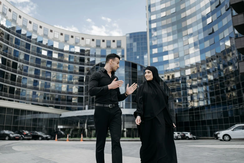 a couple walking in front of some tall buildings