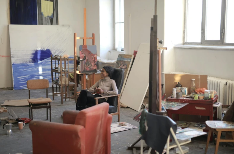 a man in a room with several pieces of furniture