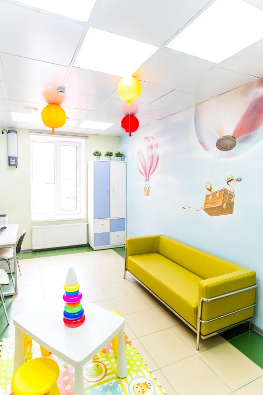 a small childrens play room that includes a yellow couch