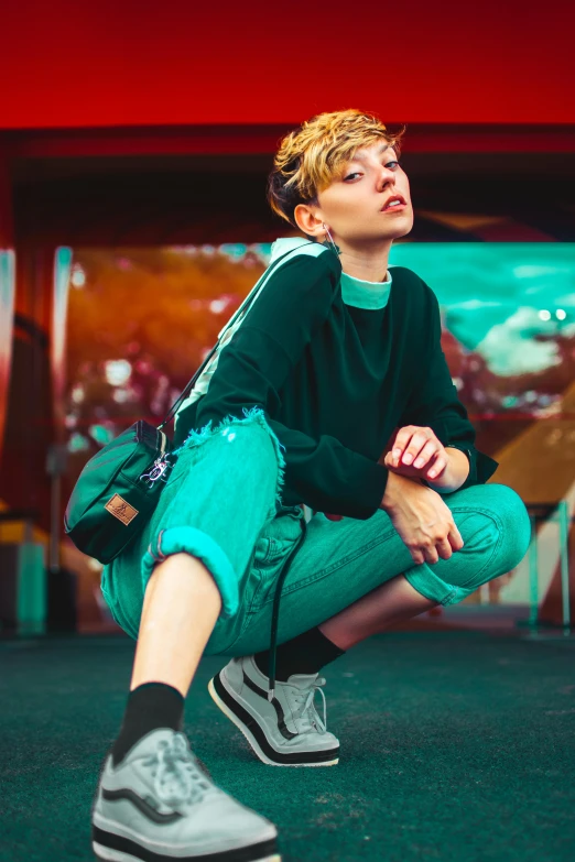 a young man kneeling down next to a backpack