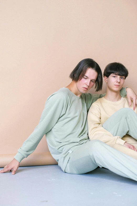 two men are posing for a po while they sit on the floor