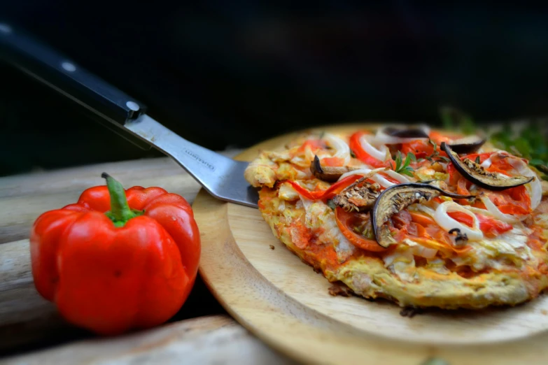 a vegetable omelet with peppers is displayed with a knife