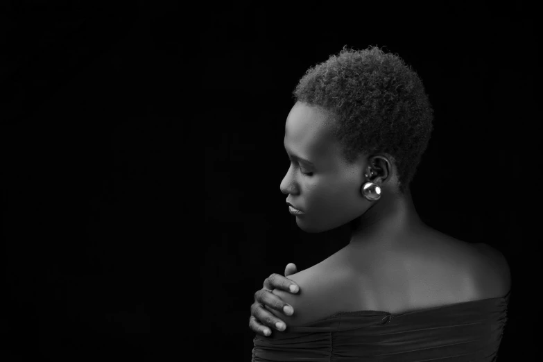 an african woman in black dress and large earrings