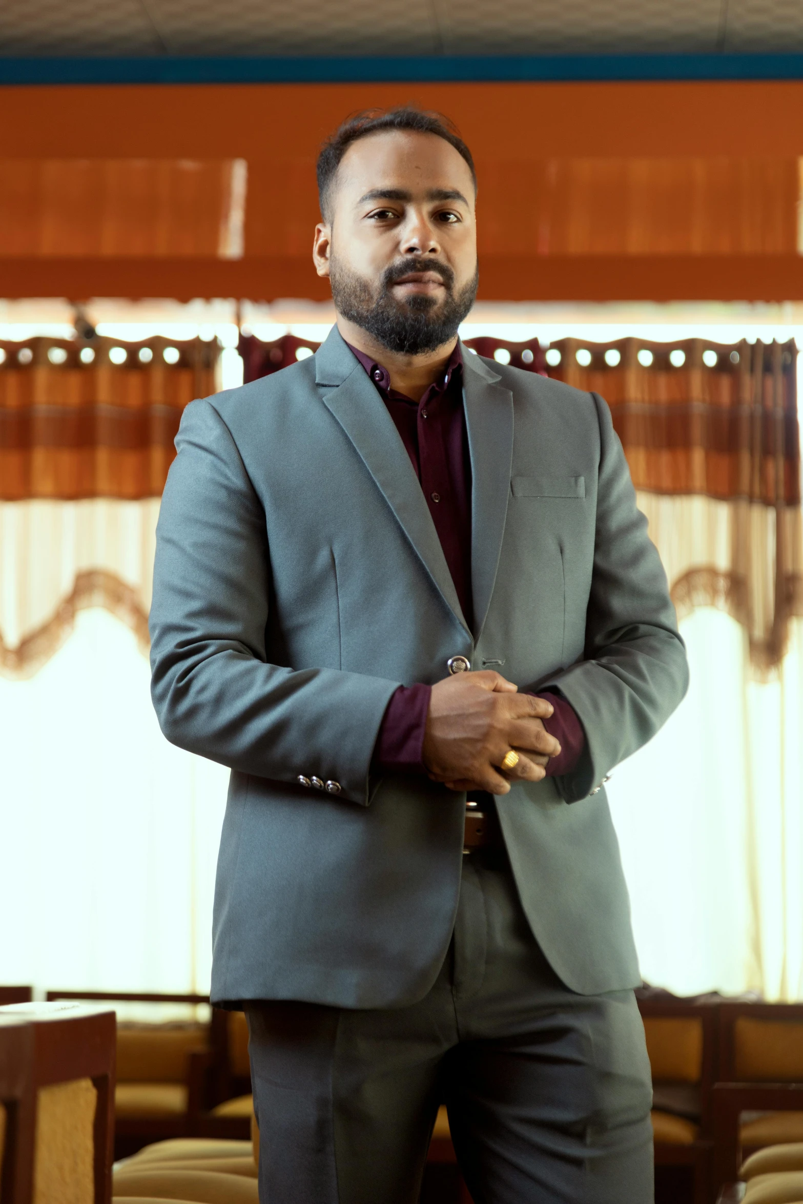 a man in a grey suit is posing for the camera