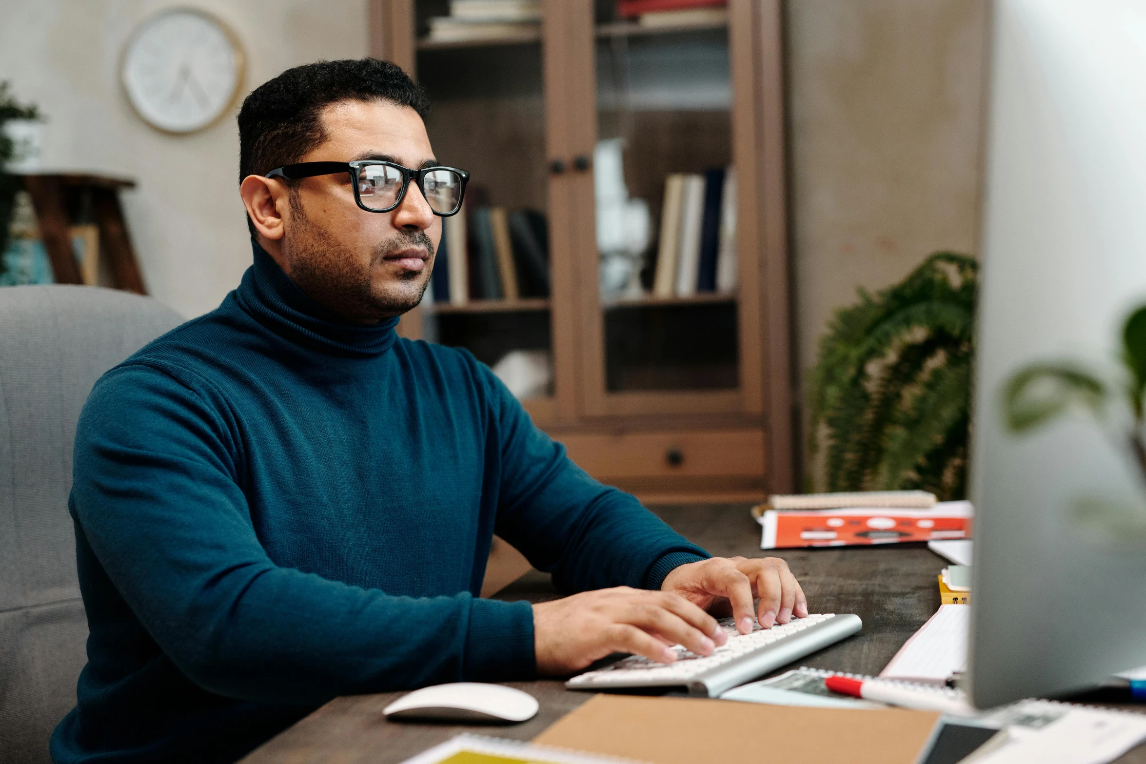 a man sitting in front of a computer on a desk