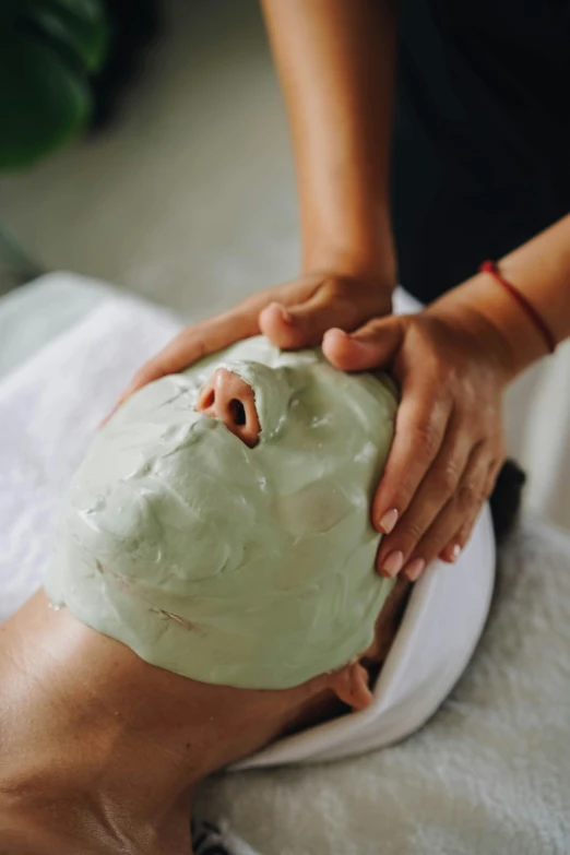 a lady holding on to a clay facial mask