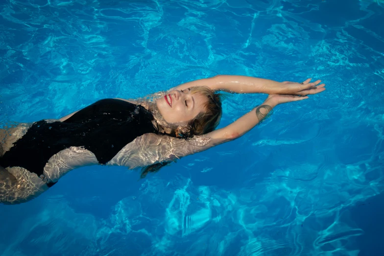 the girl is floating down in the pool