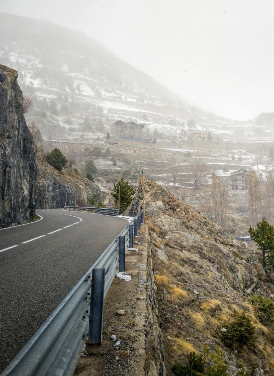 an empty mountain side road and mountain covered in snow