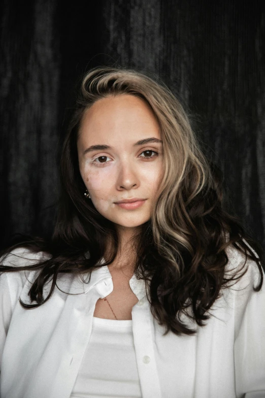 a woman wearing white poses for a pograph