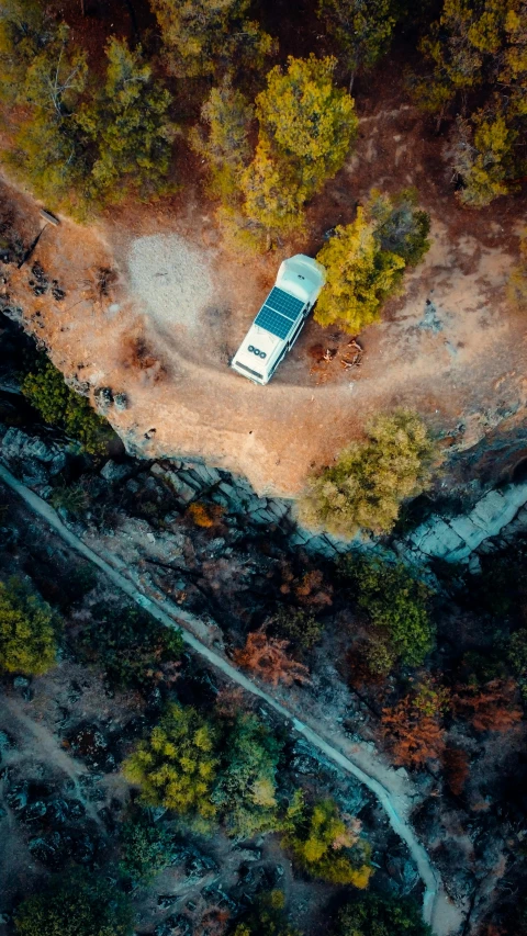 an aerial view of a white van driving down the road