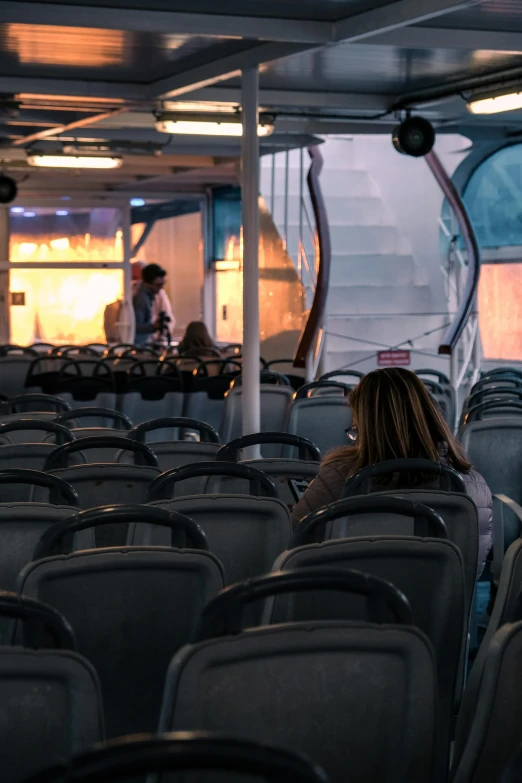 there is a girl sitting in a passenger seat on the ferry