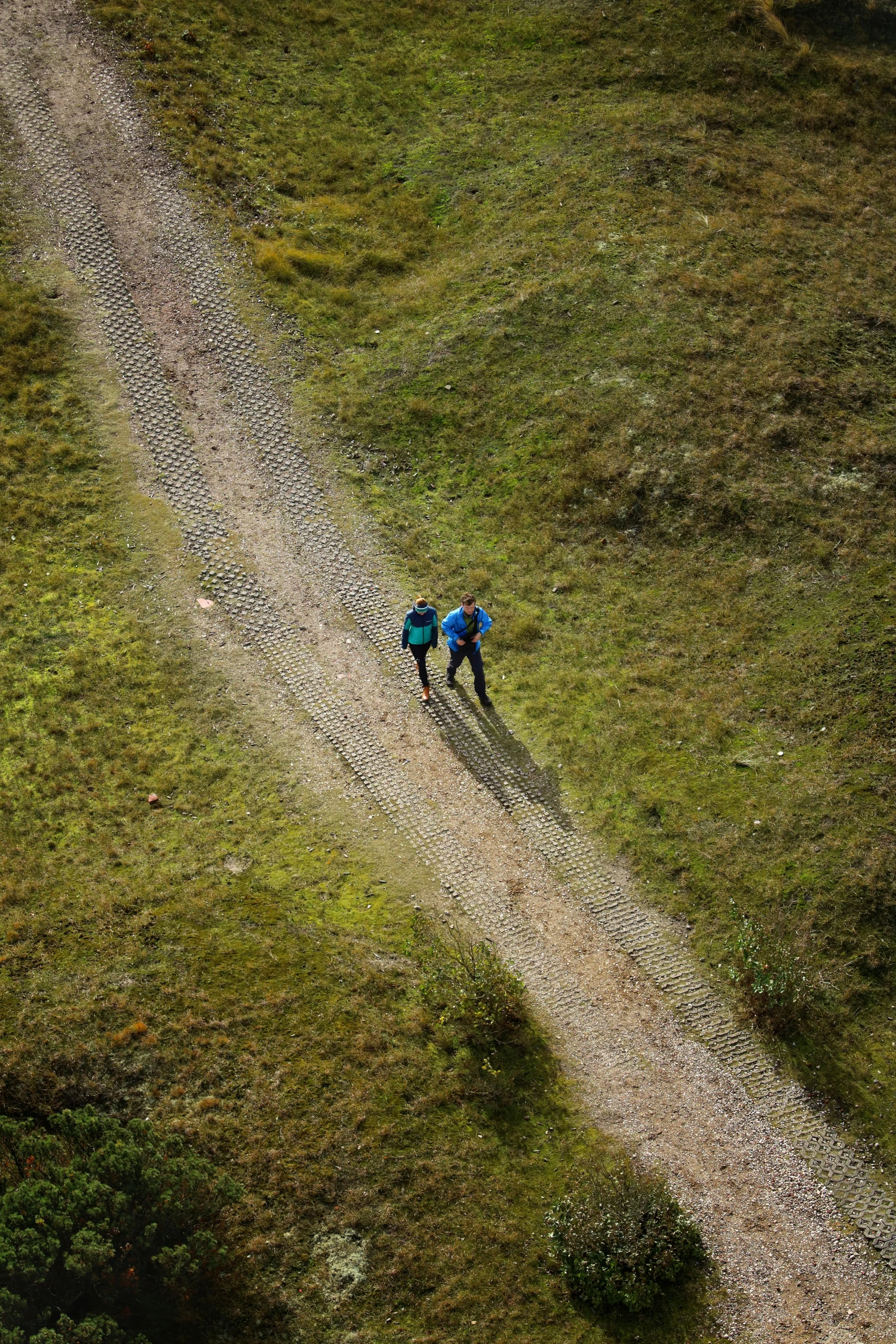 a person is riding on the back of a bike down a dirt road