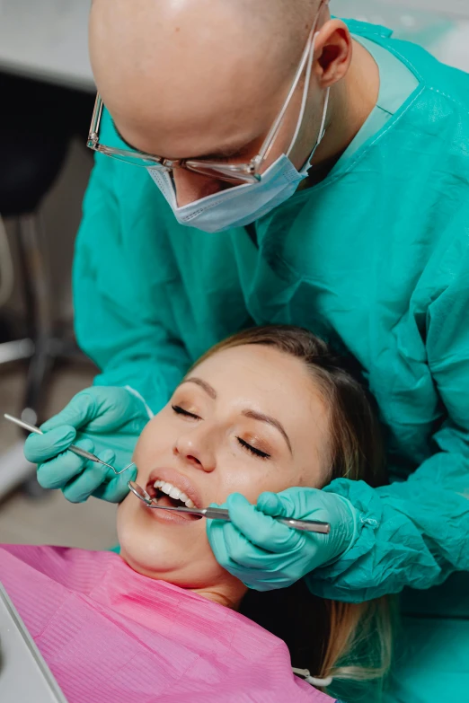 a woman getting a teeth check at the dentist