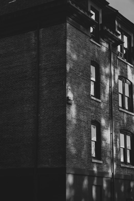 a black and white image of a brick building with several windows