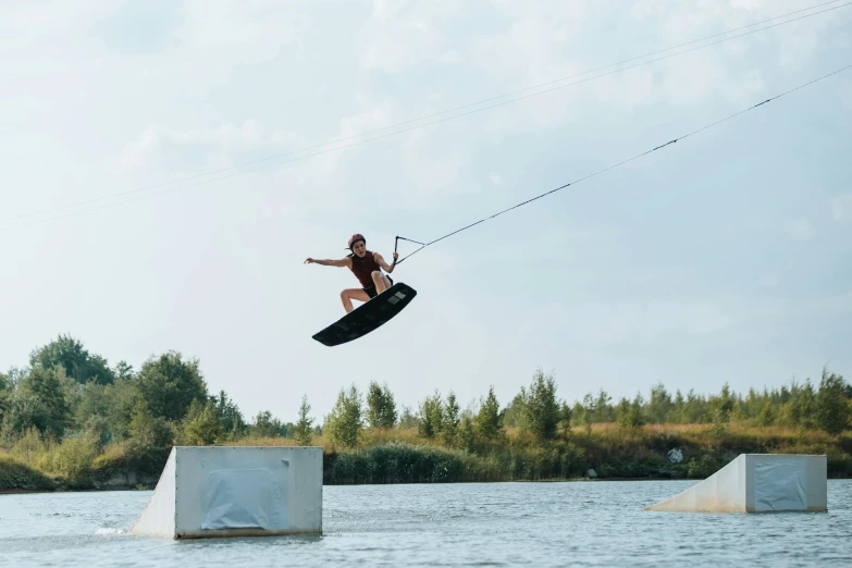 a wake boarder jumping off of a ledge in the ocean