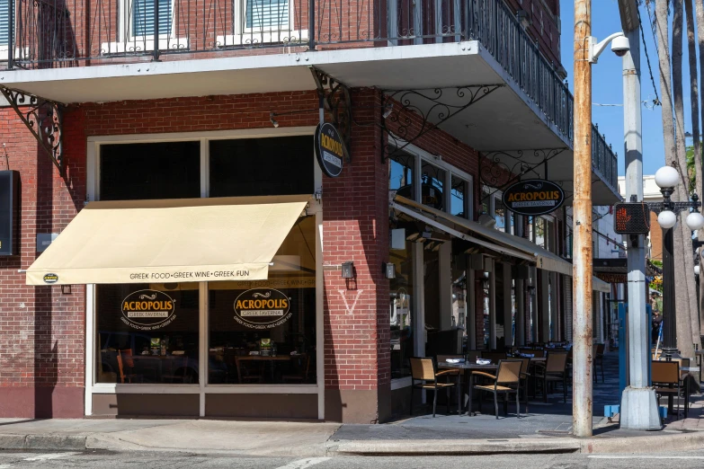 a restaurant with brown awnings sits in front of a building