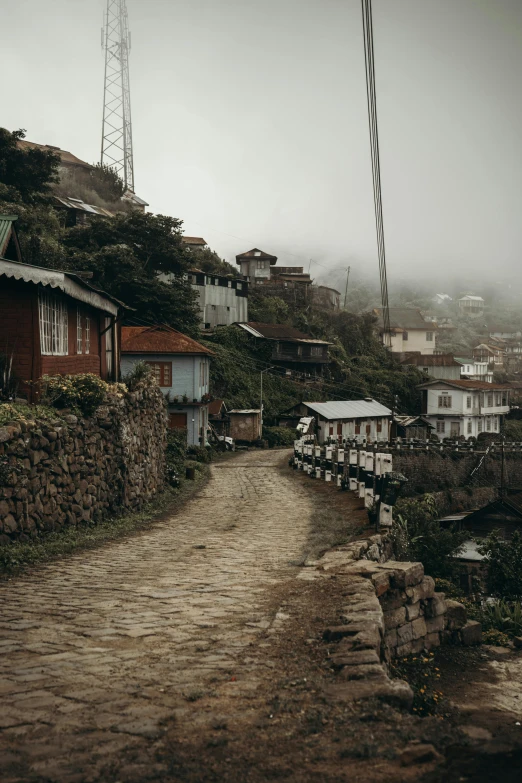 a cobble stone pathway going between houses on the hillside