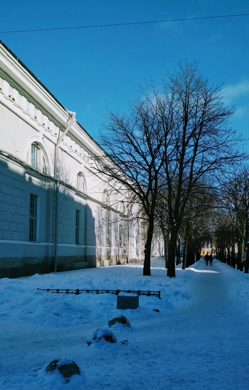 a city street with snow on the ground and a building in the background