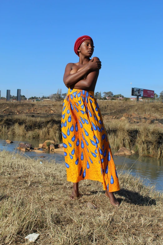 a woman is standing on the dry grass