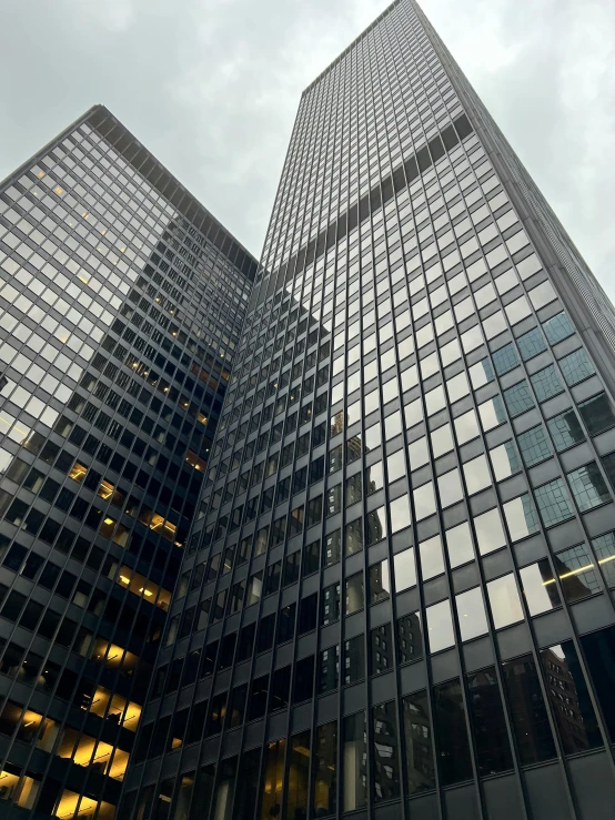 the tall buildings are mirrored in the windows