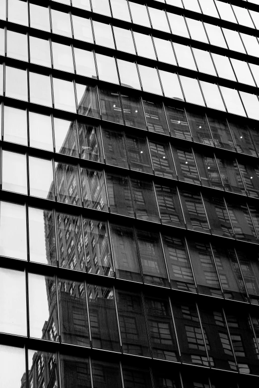 the side of an office building is reflected in the glass