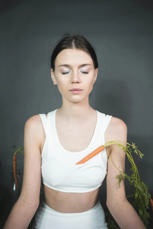 a woman in a crop top with a carrot