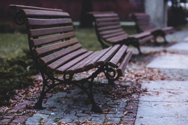 there are two benches next to each other on the sidewalk