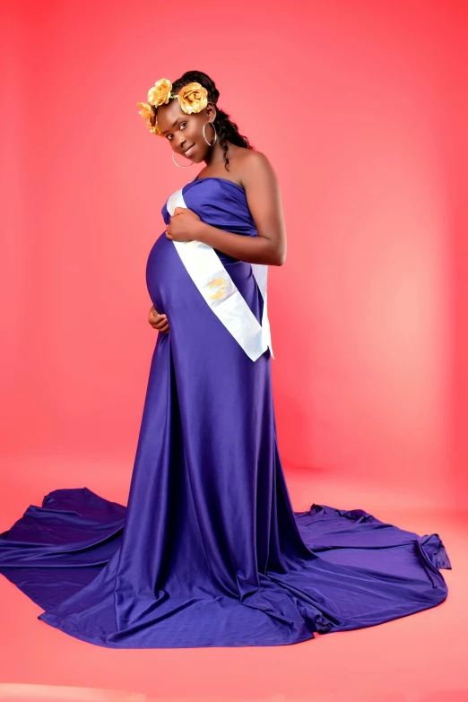 a pregnant woman in a purple dress poses for a po