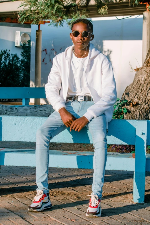 a man is sitting on a bench in front of a building