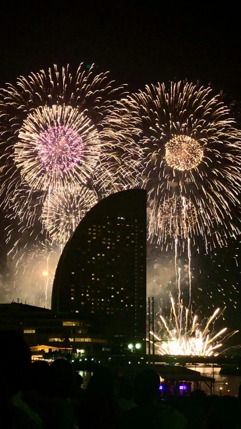brightly lit firework displays in front of buildings at night