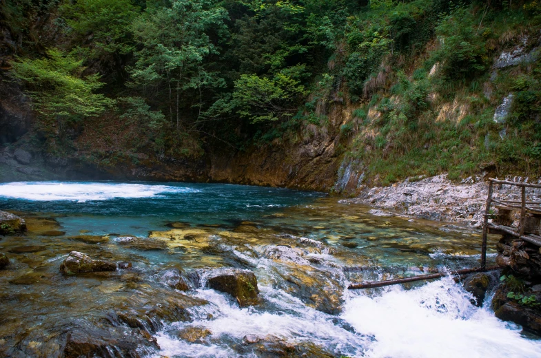 water running down a river near a rock hillside